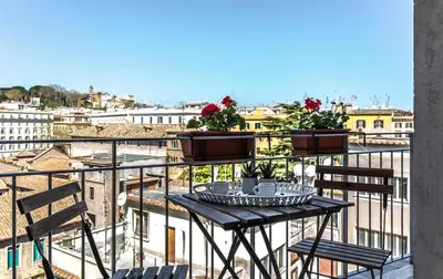 a table on a balcony with a view of a city at Top Floor Trastevere in Rome