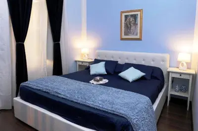 a blue bedroom with a large bed with blue sheets at B&B Alexander in Rome