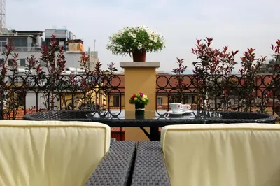 a table with chairs and a coffee cup on a balcony at Hotel Indipendenza in Rome