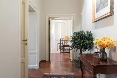 a hallway with a table and a vase of flowers at Amazing 4 bedrooms apartment with garden in Rome