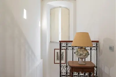 a lamp on a table in a hallway with a window at Amazing 4 bedrooms apartment with garden in Rome