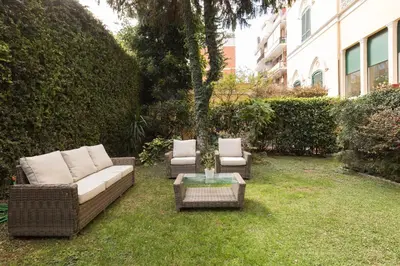 two wicker chairs and a table in a yard at Amazing 4 bedrooms apartment with garden in Rome