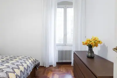 a bedroom with a bed and a vase of flowers on a table at Amazing 4 bedrooms apartment with garden in Rome