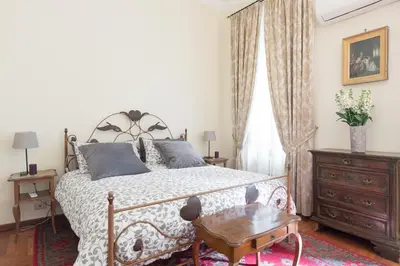 a bedroom with a large bed and a wooden table at Amazing 4 bedrooms apartment with garden in Rome