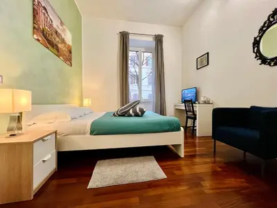 a bedroom with a bed and a desk and a chair at La Terrazza a San Pietro in Rome