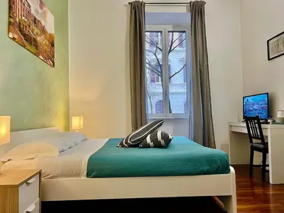 a bedroom with a bed with a desk and a window at La Terrazza a San Pietro in Rome