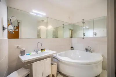 a white bathroom with a tub and a sink at Gonfalone 6 in Rome