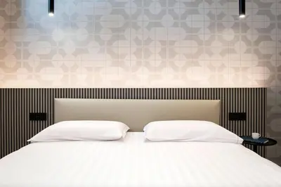 a bed with two white pillows and a wall at Gonfalone 6 in Rome