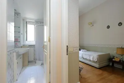 a bathroom with a sink and a bed in a room at Vatican House Via Terenzio in Rome