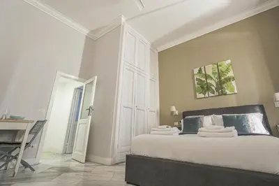 a white bedroom with a bed and a desk at SuityRHome RioneMonti37 in Rome