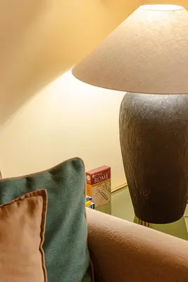 a lamp sitting next to a couch with a pillow at Luxury Apartment Pantheon in Rome