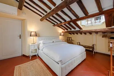 a bedroom with a white bed and a wooden ceiling at Luxury Apartment Pantheon in Rome
