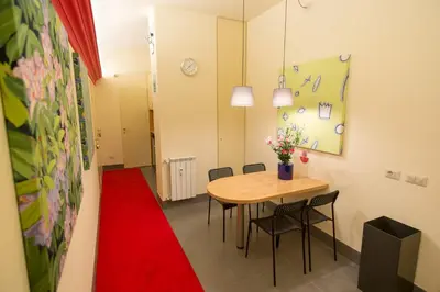 a room with a table and chairs and a red carpet at tiaspettoaroma in Rome