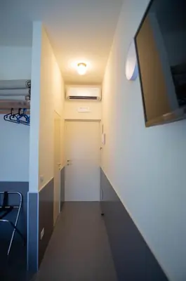 a hallway with a door and a tv on a wall at tiaspettoaroma in Rome