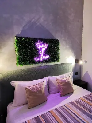 a bedroom with a bed with a neon sign above it at Chroma Italy - Chroma Deka in Rome