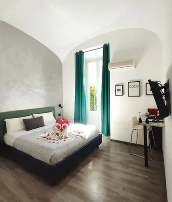 a bedroom with a bed with green curtains at Chroma Italy - Chroma Deka in Rome