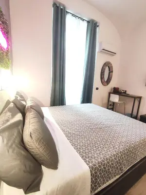a bedroom with a bed with pillows and a window at Chroma Italy - Chroma Deka in Rome