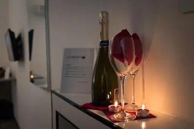 a bottle of wine and two wine glasses on a counter at Chroma Italy - Chroma Deka in Rome