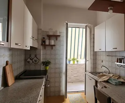 a kitchen with white cabinets and a sink and a window at Vatican Meloria House in Rome