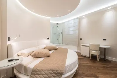 a white bedroom with a large bed and a bathroom at LUX Suites in Roma in Rome