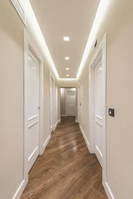 a hallway with white doors and wood floors at LUX Suites in Roma in Rome