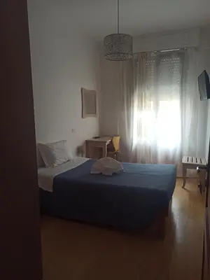 a bedroom with a bed with a blue blanket and a window at B&B Alle mura di San Giovanni in Rome