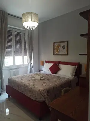 a bedroom with a bed and a chandelier at B&B Alle mura di San Giovanni in Rome
