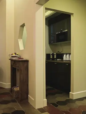 a room with a kitchen with a fireplace and a microwave at Le Stanze Di Orazio in Rome