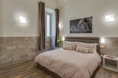 a bedroom with a large bed and a mirror at Navona Charme Suite in Rome