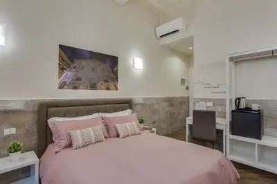 a bedroom with a pink bed and a tv at Navona Charme Suite in Rome