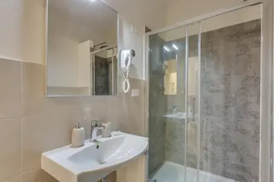 a white bathroom with a sink and a shower at Navona Charme Suite in Rome