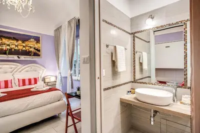 a bathroom with a bed and a sink and a mirror at Royal Vatican in Rome
