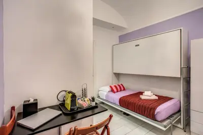 a bedroom with a bed and a desk and a mirror at Royal Vatican in Rome