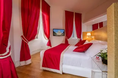 a red bedroom with a bed with red curtains at Sweet Vatican in Rome