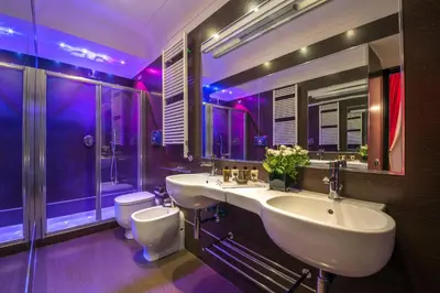 a purple bathroom with two sinks and a toilet at Sweet Vatican in Rome