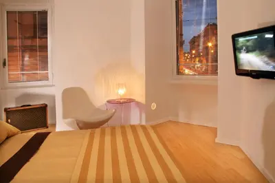 a bedroom with a bed and a tv and a chair at Sweet Vatican in Rome