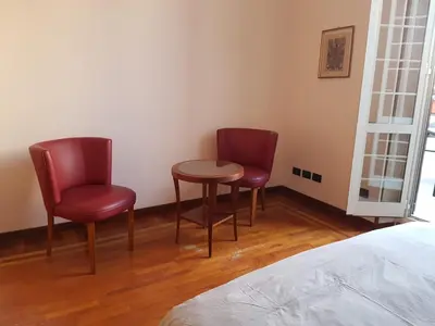two chairs and a table in a room with a bed at Chiara Rooms in Rome