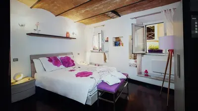 a bedroom with a white bed and a purple chair at Domus Paradiso in Piazza Navona in Rome