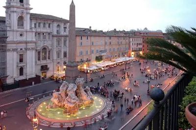 a city street with a fountain in the middle at Domus Paradiso in Piazza Navona in Rome
