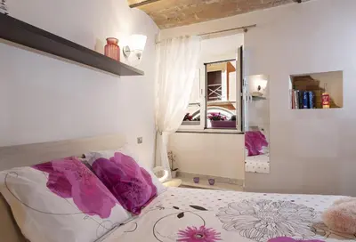 a bedroom with a bed with purple pillows and a mirror at Domus Paradiso in Piazza Navona in Rome
