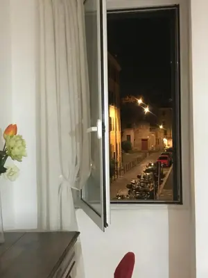 a window with a view of a street at night at Sunny Side Trastevere in Rome