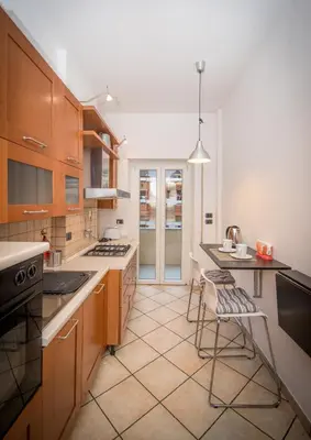 a kitchen with wooden cabinets and a table and chairs at Elettra Luxury Home in Rome