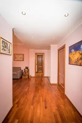 an empty living room with wooden floors and pink walls at Elettra Luxury Home in Rome