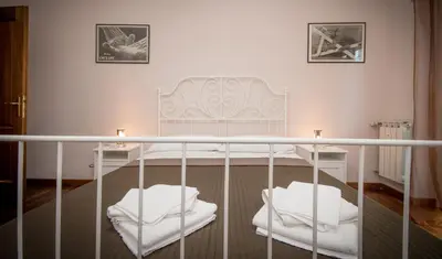 a bedroom with a white bed and two white chairs at Elettra Luxury Home in Rome
