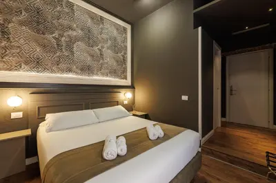 a bedroom with a large bed with white towels on it at Il Corso Comfort Rooms in Rome