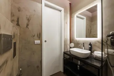 a bathroom with a sink and a mirror at Il Corso Comfort Rooms in Rome
