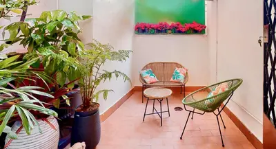 a room with two chairs and potted plants at Colosseum Charme Apartments in Rome