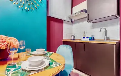 a kitchen with a table with plates and wine glasses at Colosseum Charme Apartments in Rome
