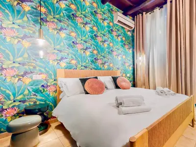 a bedroom with a large bed with a floral wallpaper at Colosseum Charme Apartments in Rome