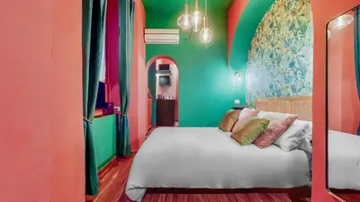 a bedroom with a white bed with colorful walls at Colosseum Charme Apartments in Rome